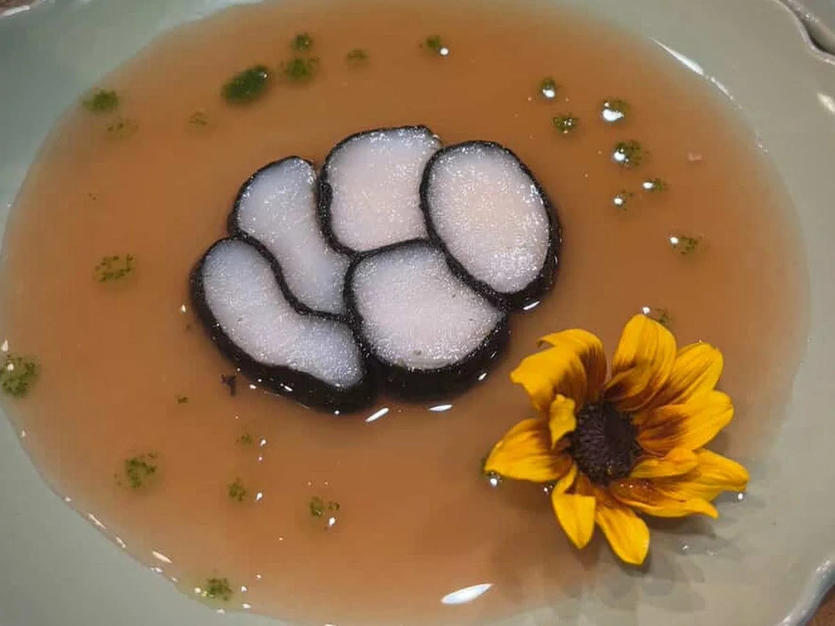 Clear consommé with tofu and a sunflower