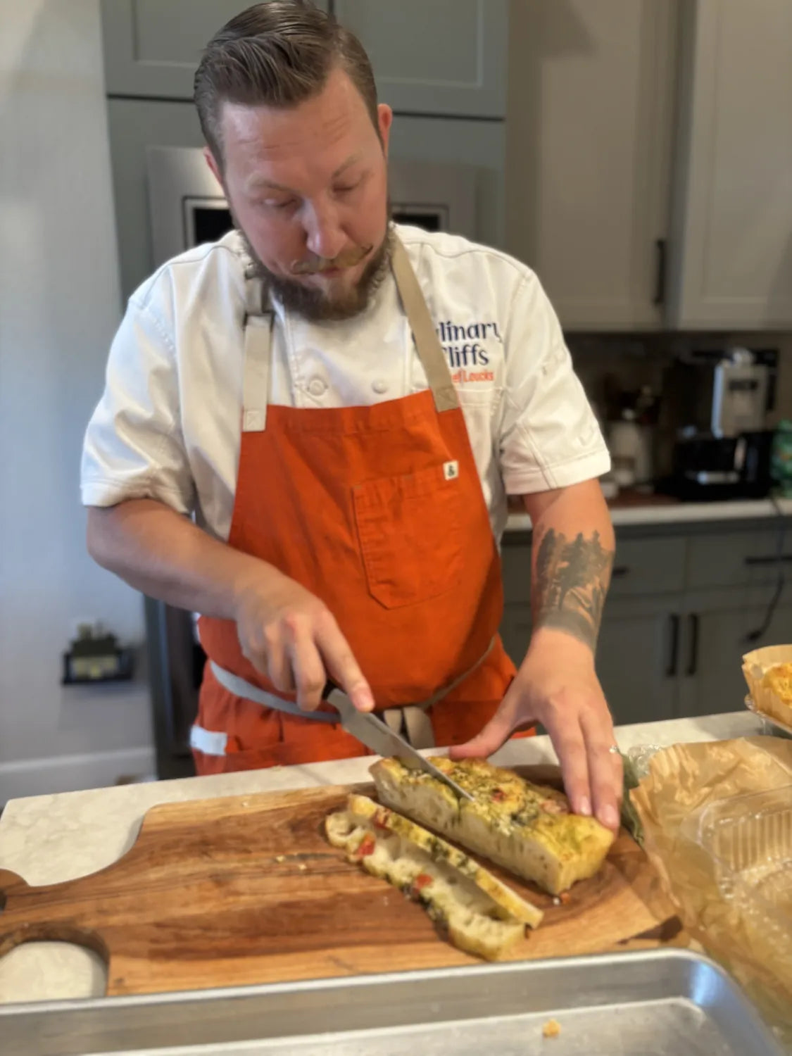 Wade slicing focaccia on a board