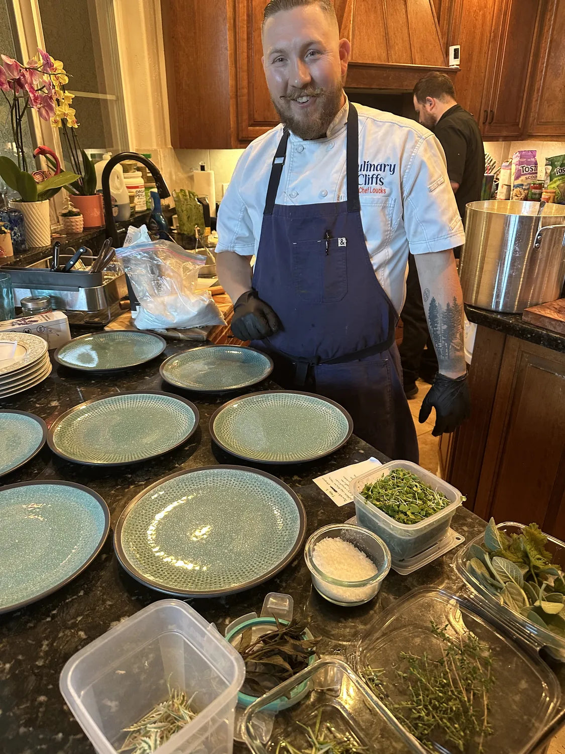 Wade in the kitchen with plates set out for service